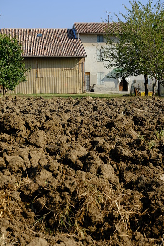 Farmhouse in the Italian countryside. Plowed land and old country house.  Stock photos. Busseto, Parma, Italy.