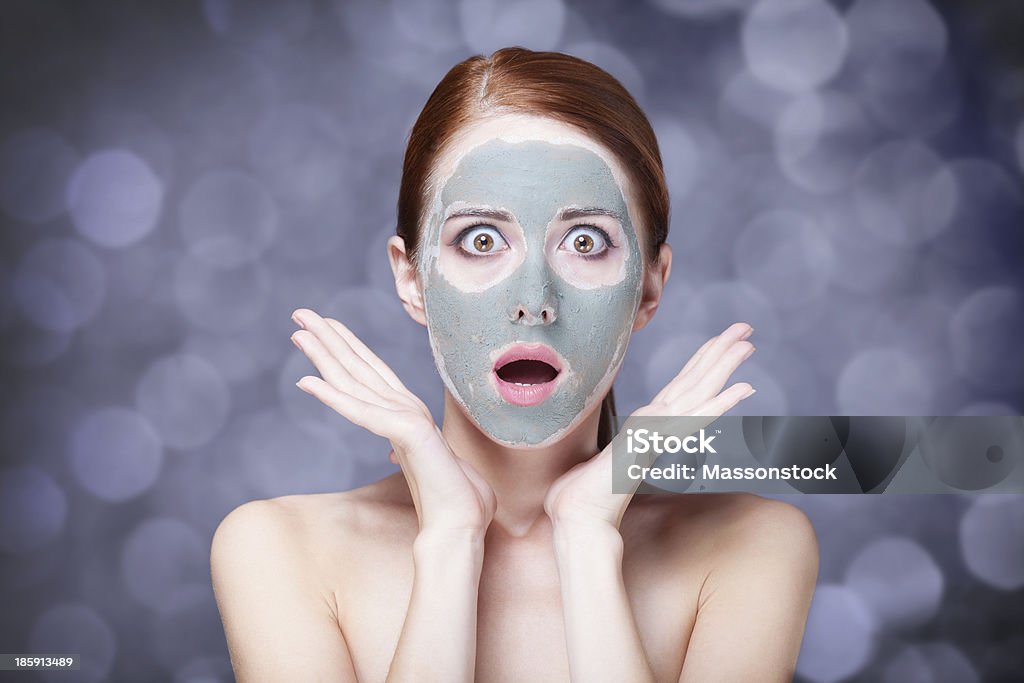women with cosmetic cream Redhead girl in cream mask. Stuido shot with bokeh Adult Stock Photo