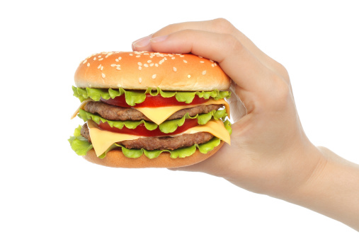 Hand holds big hamburger on white background close-up