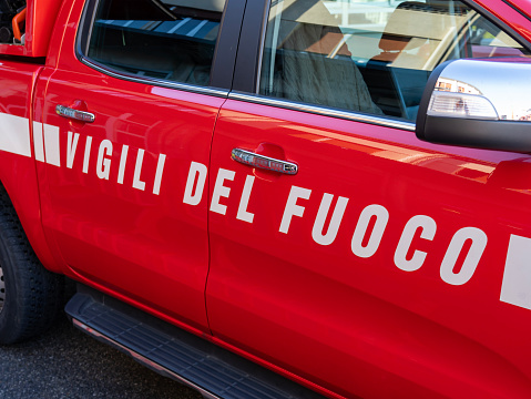 Vigili del fuoco or fire fighters sign on the side of the car. Italian fire fighters Rescue car in action in the streets of the city