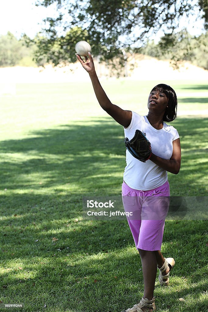 Jeune femme afro-américaine à lancer de baseball Park - Photo de Baseball libre de droits