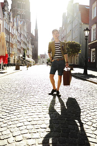 istock Young handsome man with suitcase on street 185919632