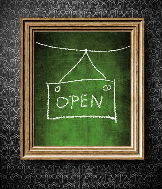 Open sign chalkboard in old wooden frame on vintage wall