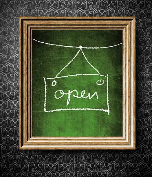 Open sign chalkboard in old wooden frame on vintage wall