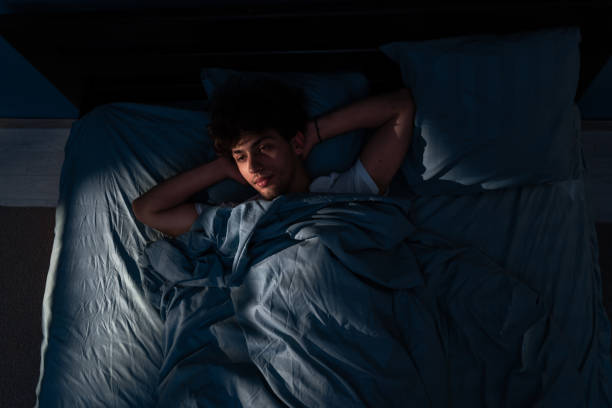 istock Arabic young man lying in bed cannot sleep from insomnia. unable sleep. Restless people. 1859217186