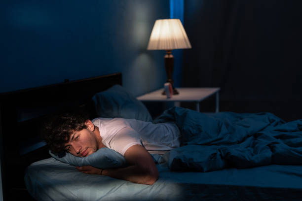 istock Arab man suffering from insomnia lying in bed with open eyes. Handsome guy in bed sleep disorder thinking about problems at night. 1859217187