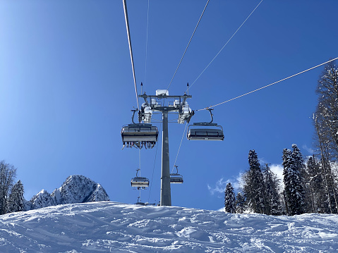 Ski lift in the mountains, people going up on the top