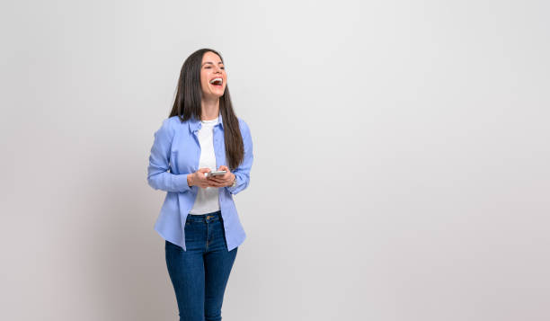 istock Female business professional laughing and looking away while using mobile phone on white background 1859237647
