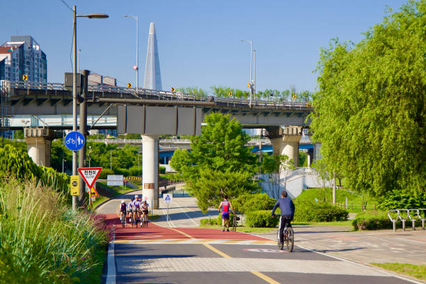 Seoul, South Korea - June 2, 2023: Cyclists enjoy a leisurely ride on the bike path near Cheonho and Gwangjin Bridges in Gwangnaru Hangang Park.