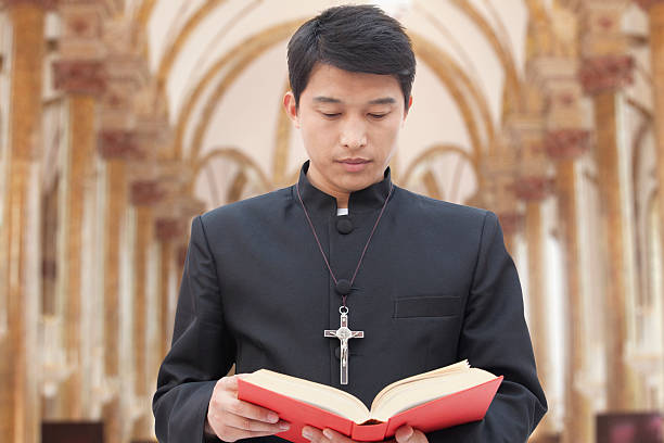 istock Priest Looking at Bible in a Church 185926022
