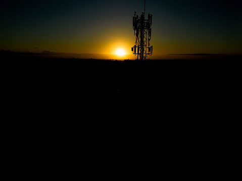 5g tower in contrast with the sunrise