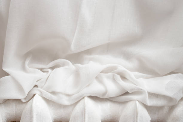 istock White drapes resting on a metal heater, abstract textures backdrop 1859268821