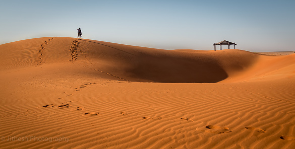 A man walking alone in the dunes early morning from Dubai