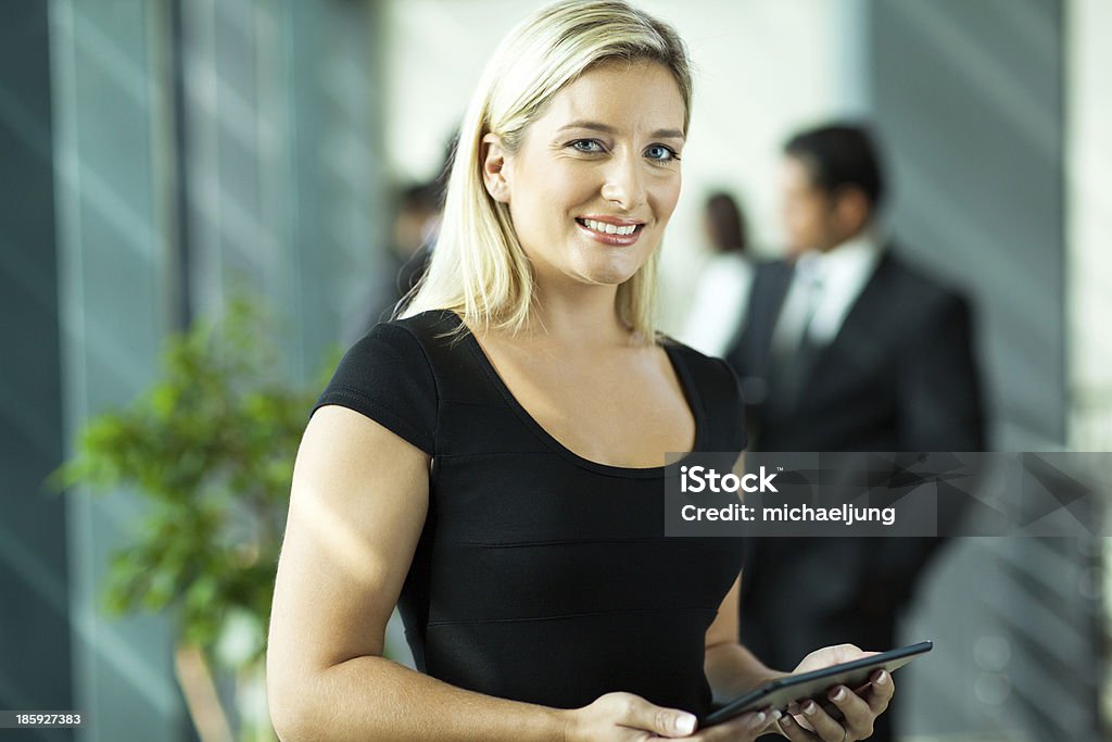 young businesswoman using tablet computer beautiful young businesswoman using tablet computer in modern office Adult Stock Photo