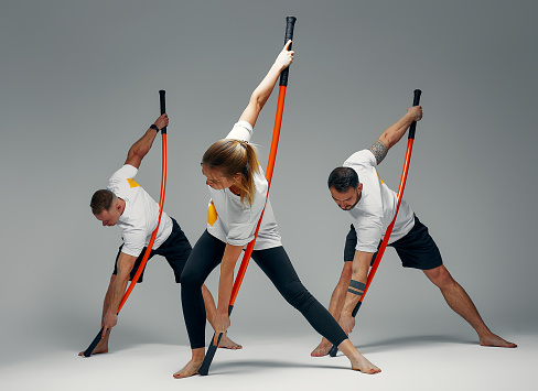 People stand together and practice sticks. Karate masters posing with sticks in the studio together.