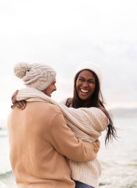 istock African woman laughing while embracing her boyfriend on a beach 1859305318