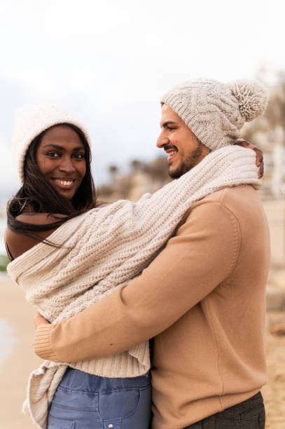 istock Multi-ethnic couple embracing on the beach in winter 1859305320