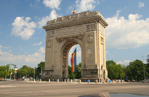 Triumphal Arch with flag Triumphal monument with national flag, Romania, Bucharest bucharest stock pictures, royalty-free photos & images