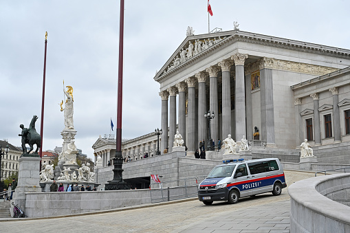 The renovated Austrian Parliament on Ringstrasse in Vienna with a police car for surveillance in front of it