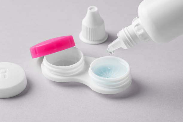 istock Pouring solution from bottle on contact lens in container on grey background 1859327023