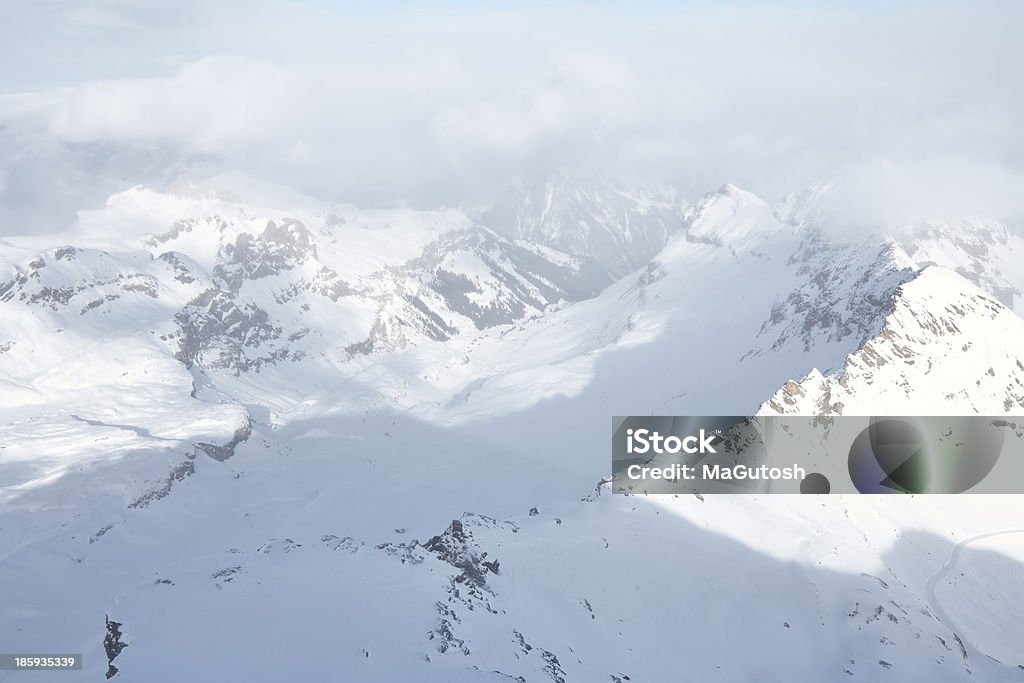 A las montañas cubiertas de nieve bajo nube de grosor - Foto de stock de Aire libre libre de derechos