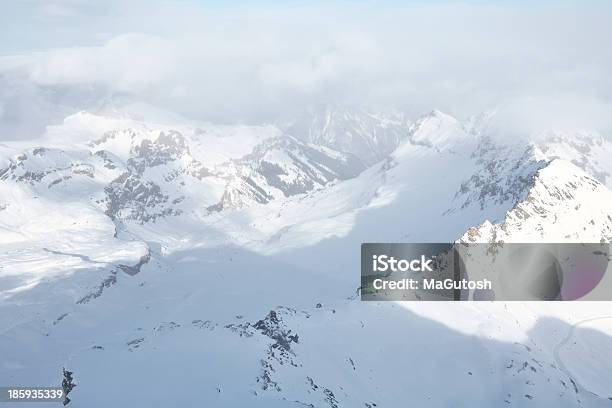 A Las Montañas Cubiertas De Nieve Bajo Nube De Grosor Foto de stock y más banco de imágenes de Aire libre