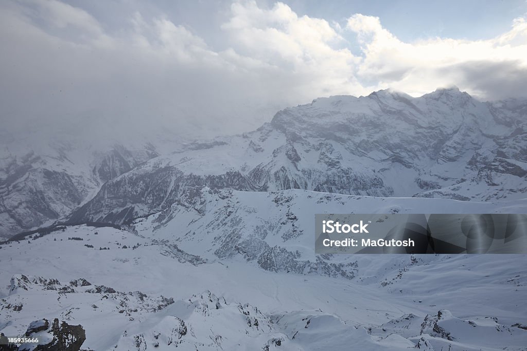 Nuvole di passaggio con il mouse sopra le mountain peaks - Foto stock royalty-free di Alpi