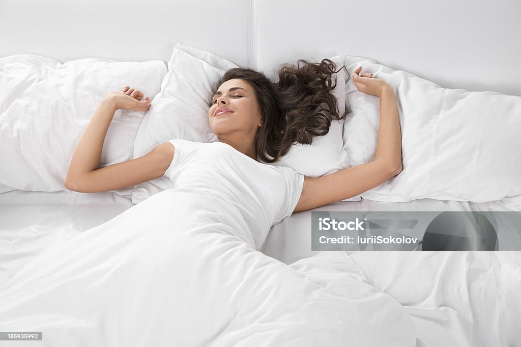 young woman sleeping on the white linen in bed young woman sleeping on the white linen in bed at home, top view Sleeping Stock Photo