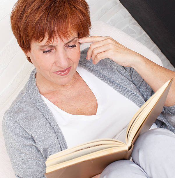 istock Adult woman reading book 185939100