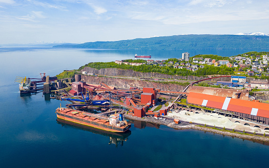 Narvik, Norway - June 20, 2023: Industrial port of Narvik with bulk carrier ship to be loaded with iron ore from Kiruna mine in Sweden
