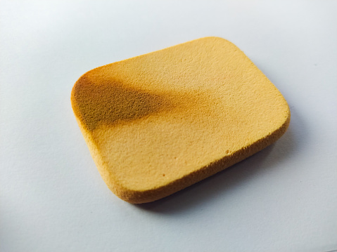 used powder sponge on a white background