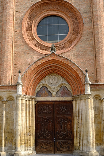 Collegiate Church of San Secondo in Asti. Circular rose window and entrance portal to the church with pointed arch.  Stock photos. Asti, Piedmont, Italy.