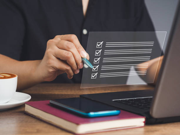 istock Checklist concept. Businessman holding a pen and writing a checkmark symbol on a document management system or DMS on a virtual screen 1859508611