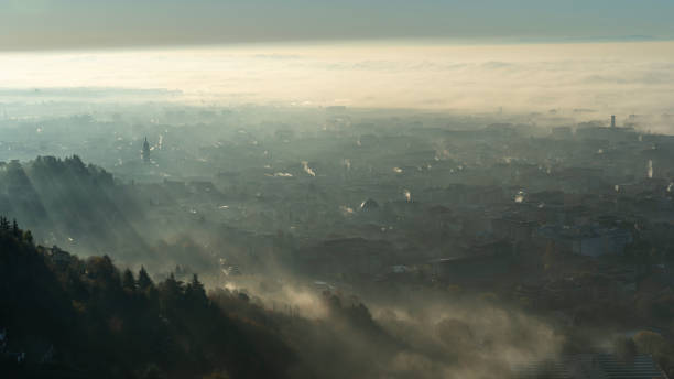 bergamo, italy. amazing aerial landscape of the new town and flat land covered by the humidity and pollution. fall season. morning time - smog city pollution town - fotografias e filmes do acervo