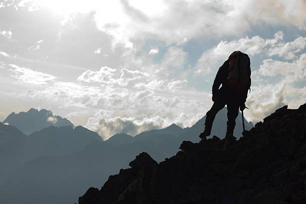 istock Hiker on top, silhouetted in high mountains 185953144