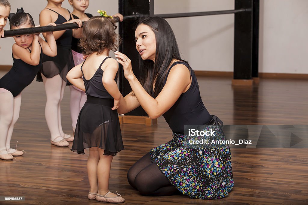 Teacher comforting a dance student Young female dance instructor comforting one of her younger ballet students during a dance class Ballet Stock Photo