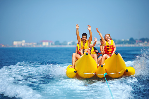 Gente feliz divirtiéndose en el bote con forma de banana photo