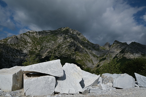Large marble stones on the mountains of the Apuan Alps in Tuscany. Destruction of the environment in a marble quarry in the Apuan Alps. The extraction of marble in the Apuan quarries produces serious environmental damage. Stock photos. Apuan Alps, Tuscany, Italy.