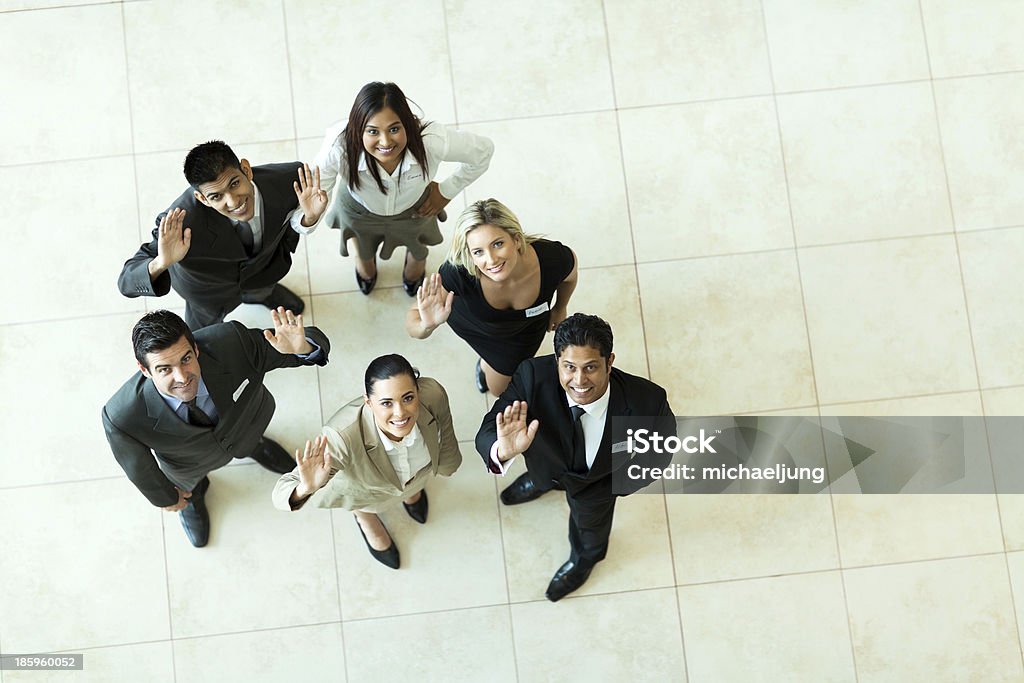 overhead view of businesspeople waving overhead view of businesspeople looking up and waving Aerial View Stock Photo