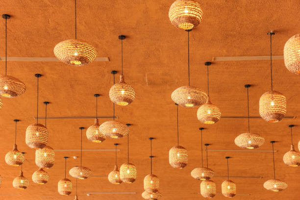 istock Stylish irregular straw like lamp shades on orange ceiling 1859629079