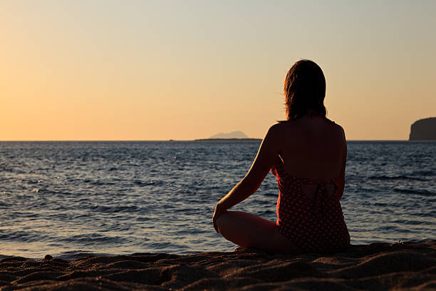 istock Woman meditation on the beach 185965069