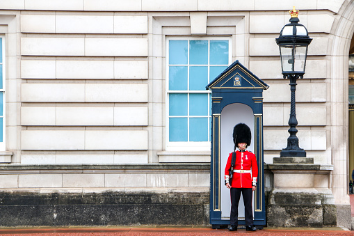 One of the King and Queens guards outside Buckingham Palace, home of the British royal family, landmark building and tourist attraction in London, England, UK