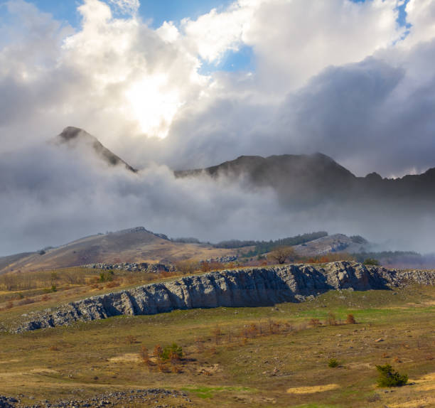 istock mountain valley in dense mist and clouds at the sunset 1859660102