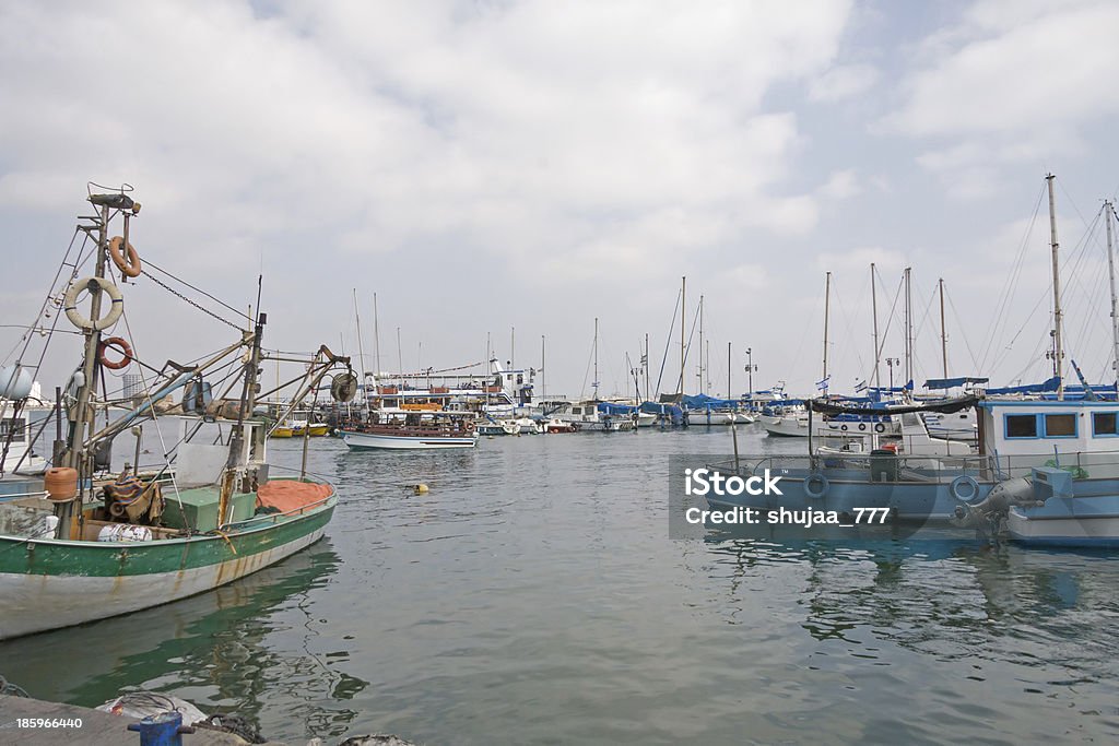 Barcos ancorados no porto de madeira contra o céu nublado fundo - Foto de stock de Acco royalty-free