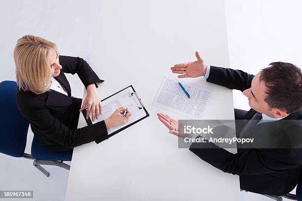 Two Businesspeople Talking With Each Other Stock Photo - Download Image Now - Adult, Adults Only, Analyzing