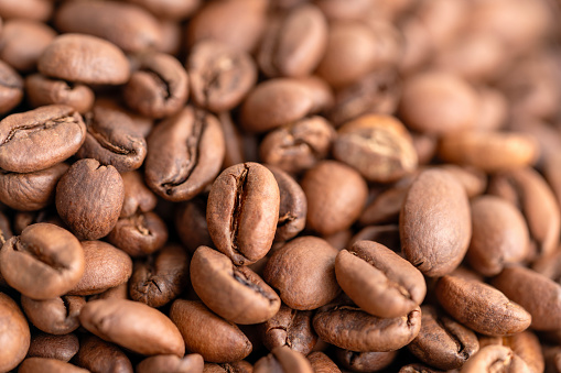 Roasted coffee beans 3d rendering background. Masses of coffee beans close up. Few golden beans