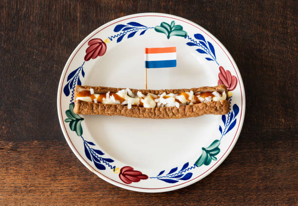 Frikandel speciaal, a traditional dutch fast food snack consisting of minced meat sausage, mayonnaise, curry and chopped raw onion Top-down view of frikandel speciaal with dutch flag frikandel speciaal stock pictures, royalty-free photos & images