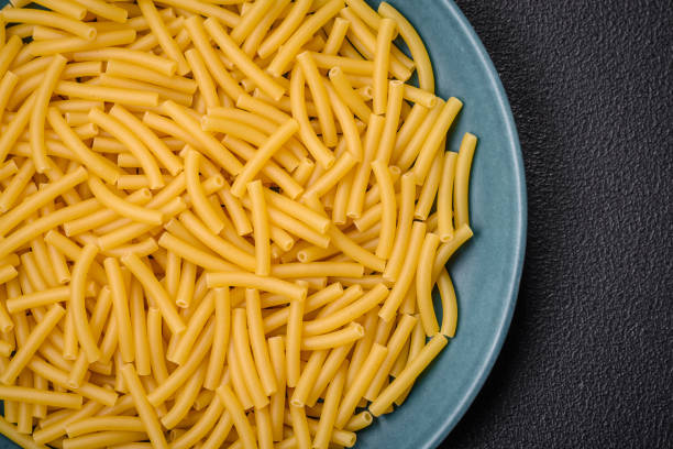 istock Raw whole grain wheat pasta with salt and spices in a ceramic plate 1859714436