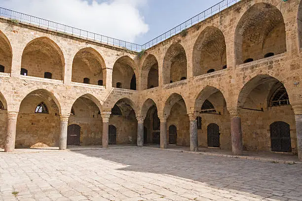 Arched gallery of Khan al-Umdan viewed from paved courtyard. Old city of Acre, Israel.