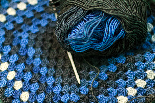 Metal crocheting hook with ball of yarn stock photo